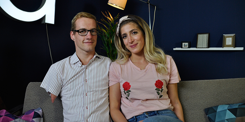 Ein Mann mit stark verkürzten Gliedmaßen und eine Frau sitzen auf dem Sofa