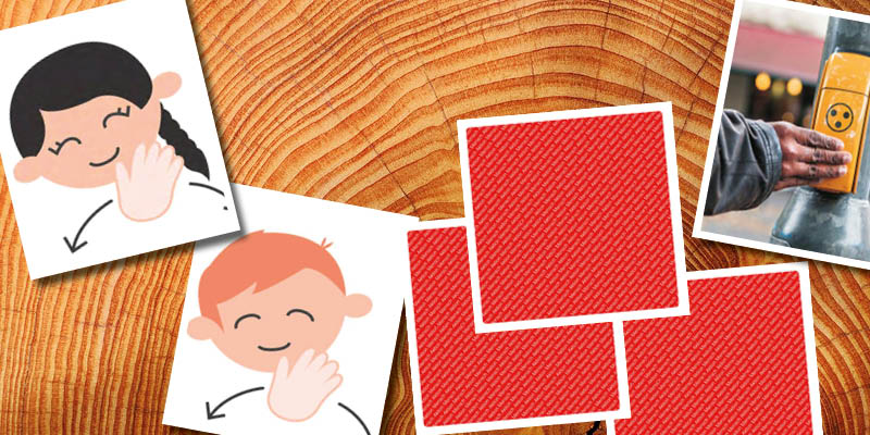 Karten des Memory-Spiels InkluMemo legen zum Teil aufgedeckt, zum Teil zugedeckt auf einem Holztisch.