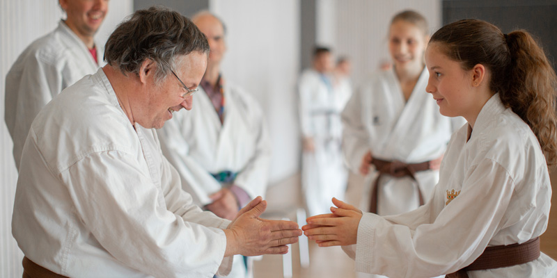 Ein Mann und ein Mädchen üben gemeinsam Karate.