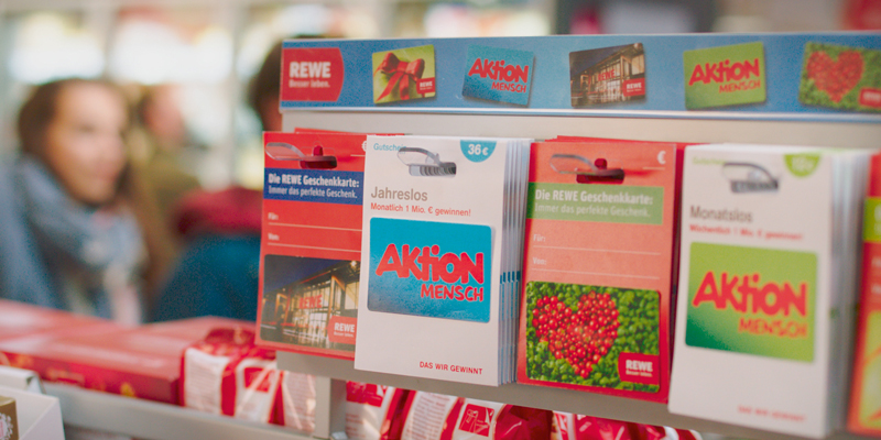 Lose der Aktion Mensch an der Kasse bei REWE