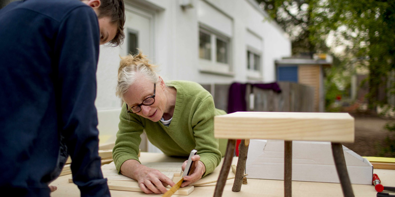 Eine Frau und ein Junge arbeiten gemeinsam an einer Werkbank