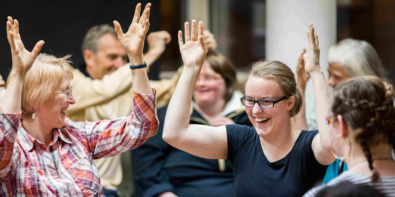 Zwei Frauen lachen gemeinsam und machen eine Gebärde.