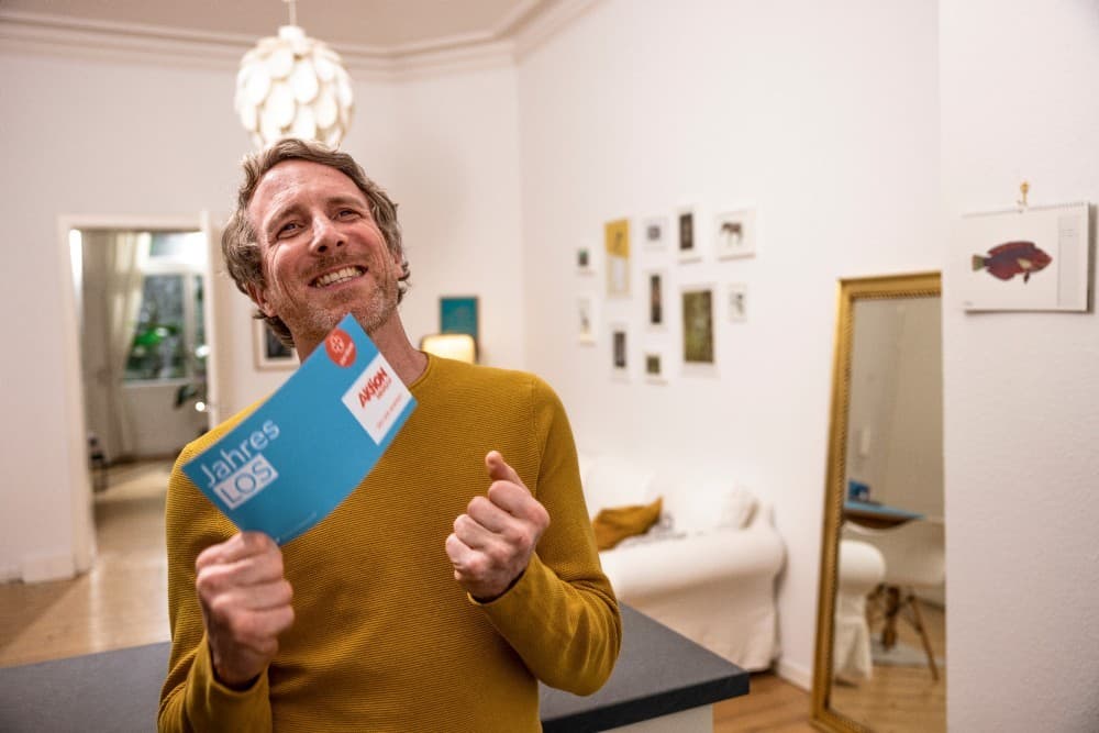 Ein Mann freut sich über ein Los von Aktion Mensch