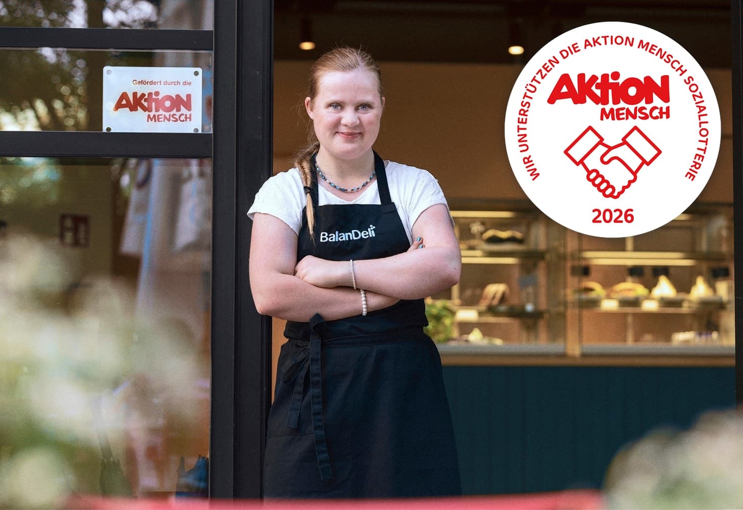 Eine junge Frau steht vor ihrem Geschäft